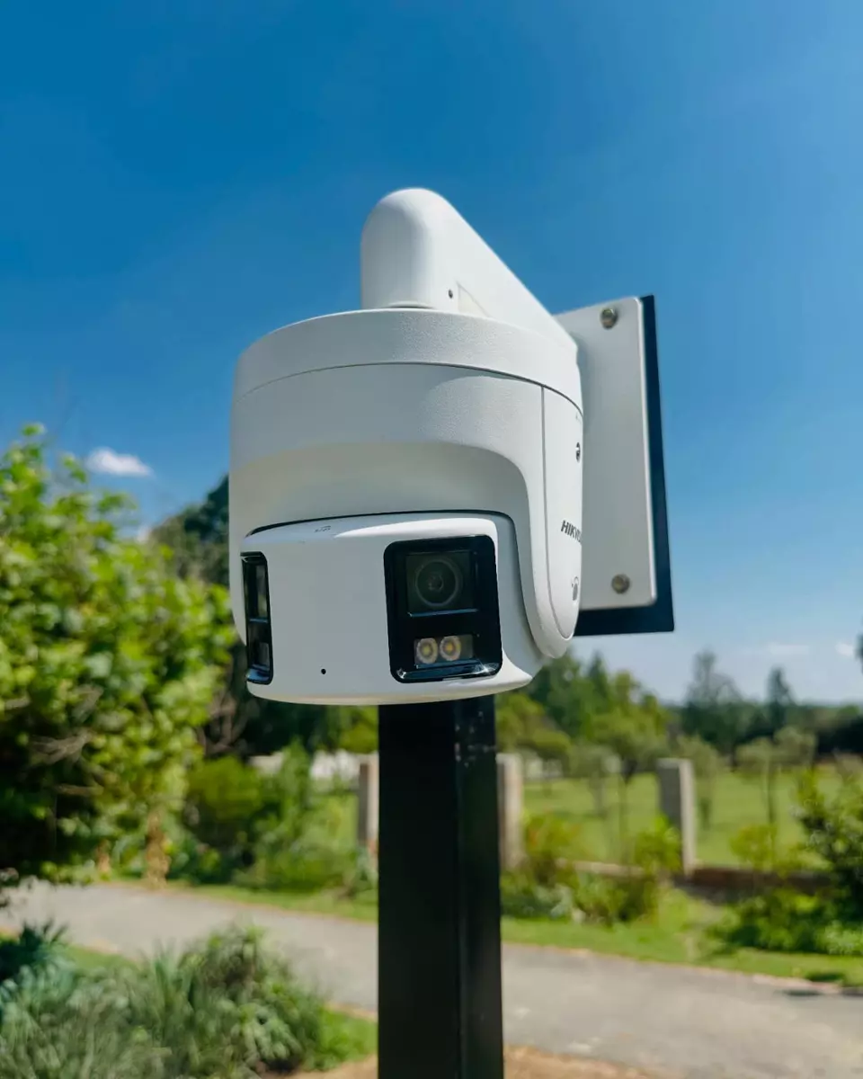 White security camera mounted on a pole outdoors